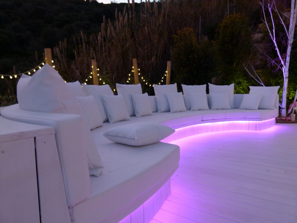 banco curvo de madera chill out con iluminación violeta