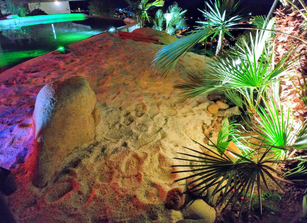 zuperficie de arena de playa cerca de piscina moderna en mansión. fotografia nocturna